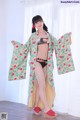 A woman in a bikini and a kimono posing for a picture.